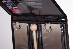 Open binder with rings and wooden tool.