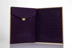 Purple patterned folder with gold button closure.