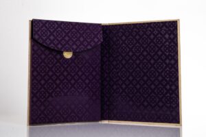 Purple patterned open envelope with gold button.