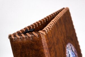 Brown leather-bound photo album with stitching.