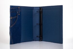 Denim-themed binder with three-ring mechanism.