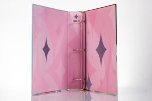 Pink binder with star pattern inside.