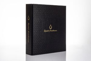 Black embossed box with gold writing.