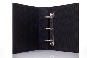Open black binder with metal rings.