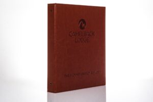 Brown Camelback Lodge binder on white background.