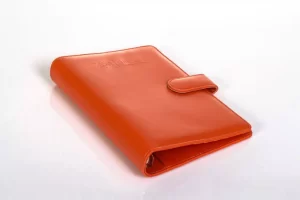 Orange leather notebook with a button closure.