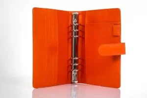 Orange leather binder with metal rings open.