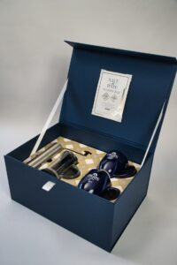 Blue gift box with personalized items inside.