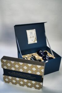 Blue gift box with items and card.