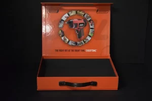 Orange power drill in an open box.