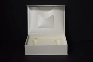 Open white box with compartments, black background.