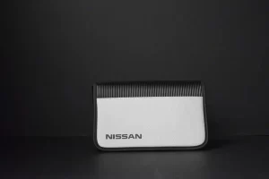 Nissan branded pouch against dark background.