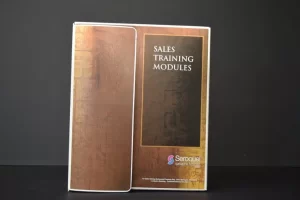Sales training modules booklet on display.