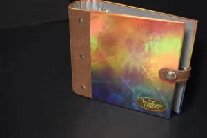 Colorful binder with brown leather strap.