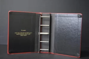 Empty red binder with metal rings open.