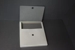 Metal wall-mounted brochure holder on black background.