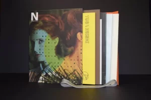 Colorful books stacked on a dark surface.