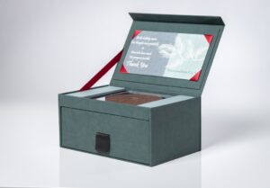 Green gift box with open lid and card.