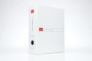White binder with red label, upright position.