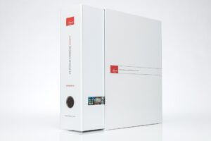 White binder with red label and text.