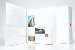 White promotional folder with architectural images displayed.