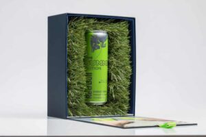 Green energy drink can in grass-lined box.