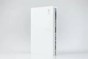 White book partially opened on gray background.