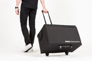 Person pulling large black wheeled case.