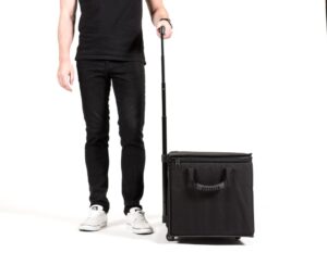 Person with rolling black suitcase on wheels.