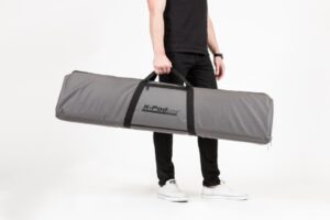 Person holding large gray carrying bag.