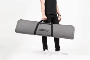 Person carrying large gray bag.