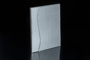 Silver metallic tile with curved line design.