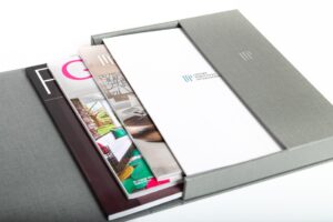 Magazines and documents in a gray box.