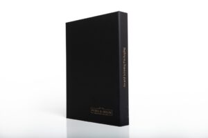 Black book standing on white surface.