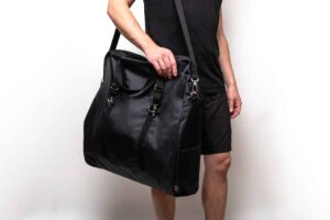 Person holding large black shoulder bag.