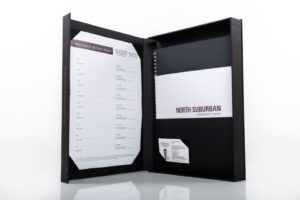 Open binder with documents and business card.